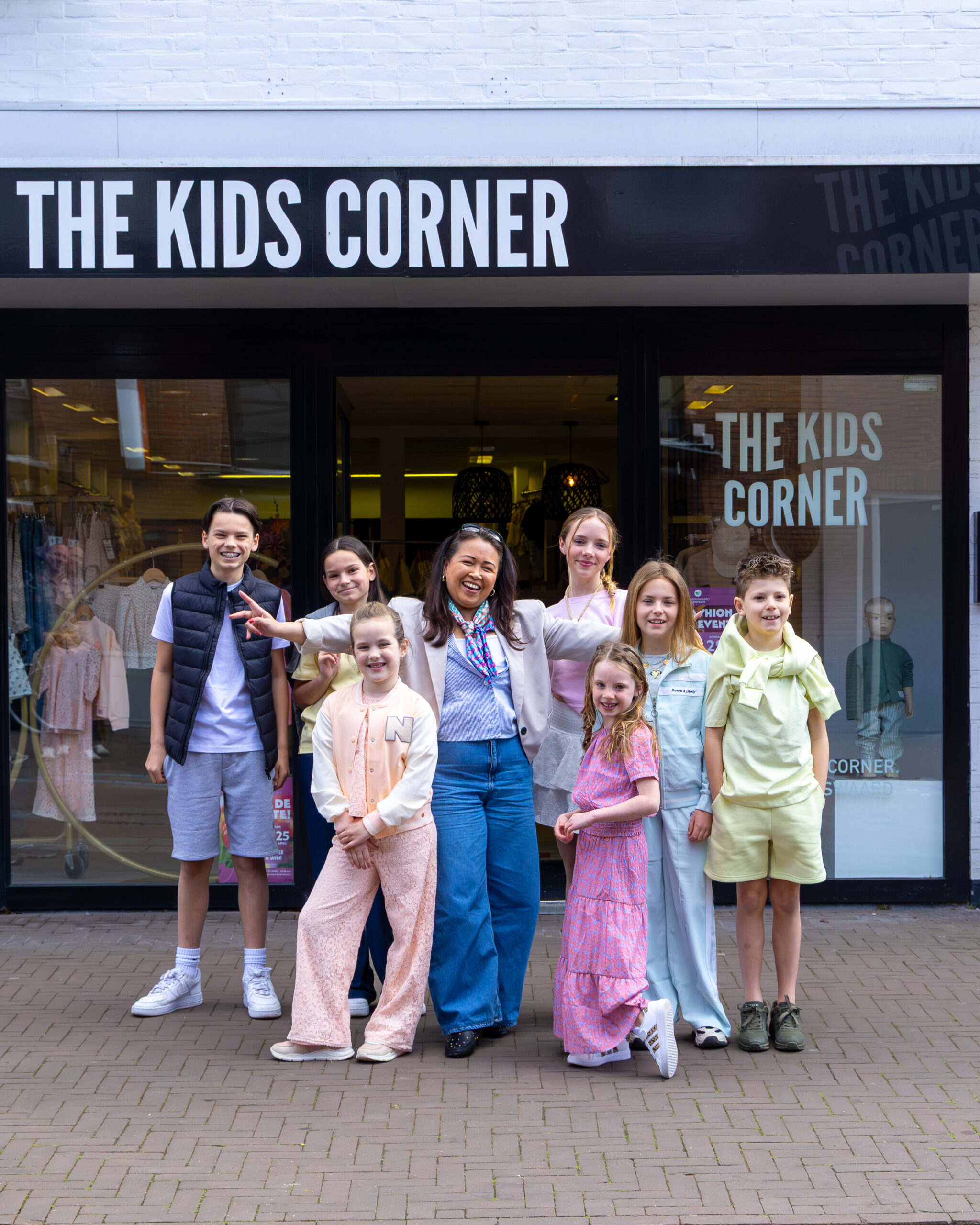 Ineke met kinderen voor de winkel van The Kids Corner