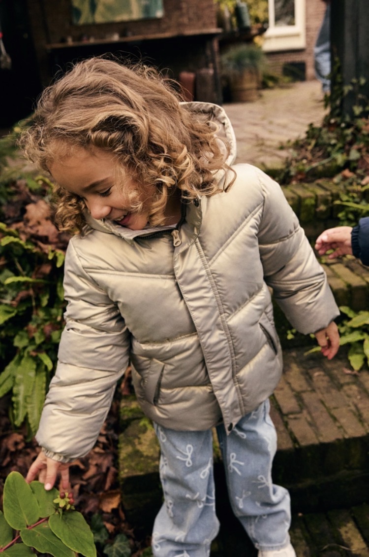 Meisje in beige winterjas buiten